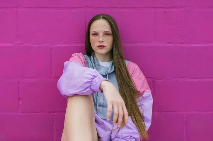 Framed Print : Trendy teenager with roller skates sitting near pink wall Framed Print : Trendy teenager with roller skates sitting near pink wall