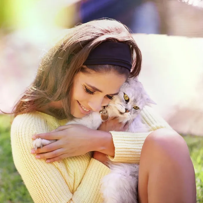 Framed Print : Trendy young woman with Persian cat cuddling and loving her grey feline while sitting on the grass outside at park