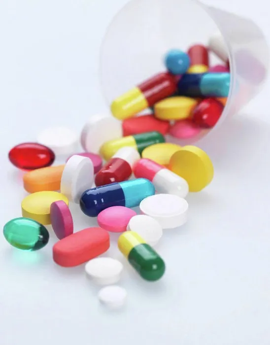 Framed Print : A variety of pills falling out of plastic measuring container