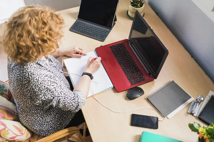 Framed Print : From above view of anonymous female freelancer taking notes with pen in notebook while listening music in earphones Framed Print : From above view of anonymous female freelancer taking notes with pen in notebook while listening music in earphones