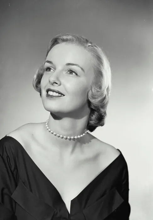 Framed Print : Vintage Photograph. Smiling blonde woman wearing black evening gown and pearl necklace looking up and off camera Framed Print : Vintage Photograph. Smiling blonde woman wearing black evening gown and pearl necklace looking up and off camera