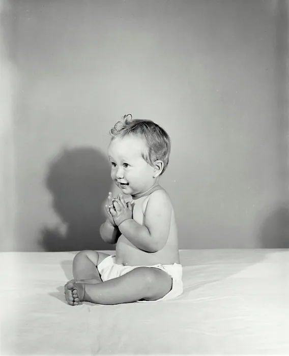 Framed Print : Vintage Photograph. Baby clapping hands and looking to the left of frame