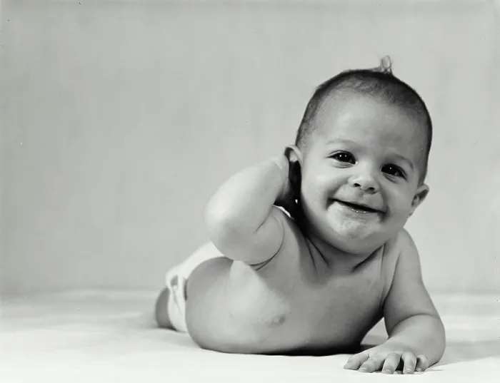 Framed Print : Vintage Photograph. Baby crawling with hand behind head smiling