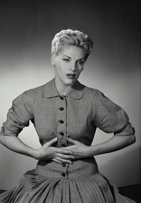 Framed Print : Vintage Photograph. Blonde woman with short hair holding hands to stomach in discomfort
