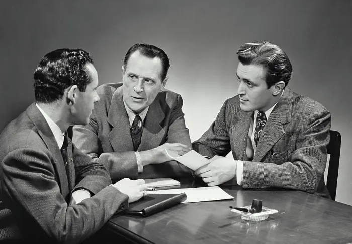 Framed Print : Vintage photograph. Group of businessmen sitting at desk having meeting