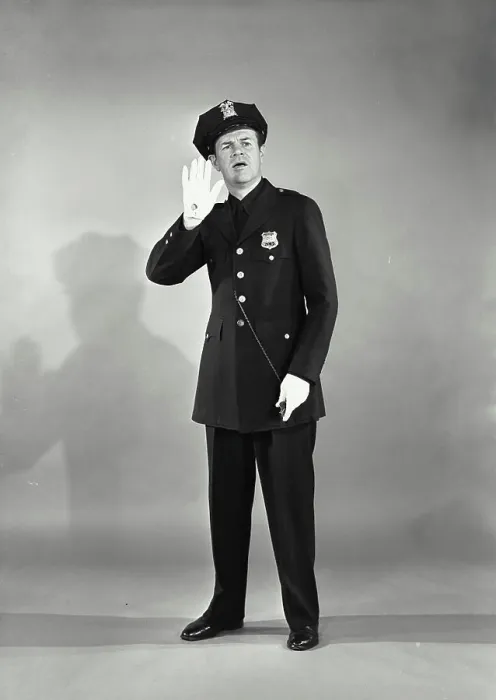 Framed Print : Vintage photograph. Full length portrait of policeman with whistle with hand raised looking concerned