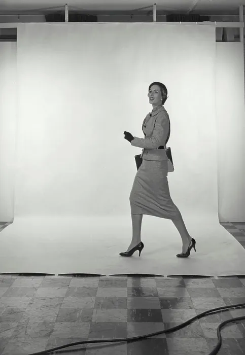 Framed Print : Vintage Photograph. Full length view of woman wearing light grey skirt and jacket and hat on white studio background
