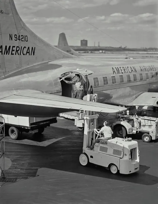 Framed Print : Vintage photograph. Man opening cargo door on American Airlines plane while standing on forklift pallet Framed Print : Vintage photograph. Man opening cargo door on American Airlines plane while standing on forklift pallet