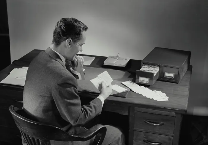 Framed Print : Vintage Photograph. Man in suit sitting at desk covered in papers. Frame 4 Framed Print : Vintage Photograph. Man in suit sitting at desk covered in papers. Frame 4