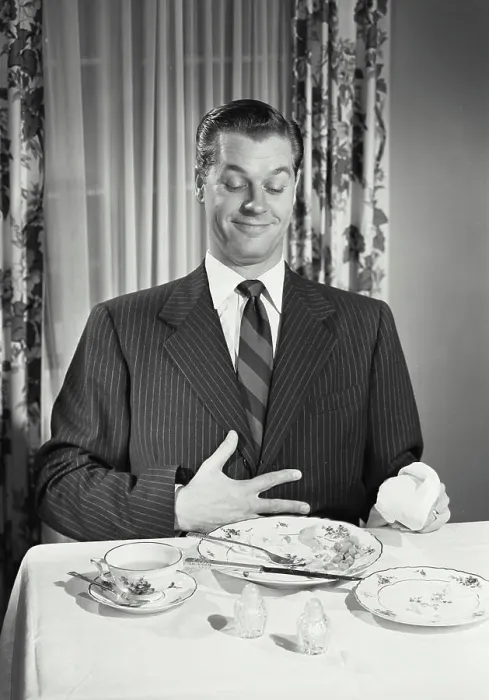 Framed Print : Vintage photograph. Man at table holding full stomach with empty plates Framed Print : Vintage photograph. Man at table holding full stomach with empty plates