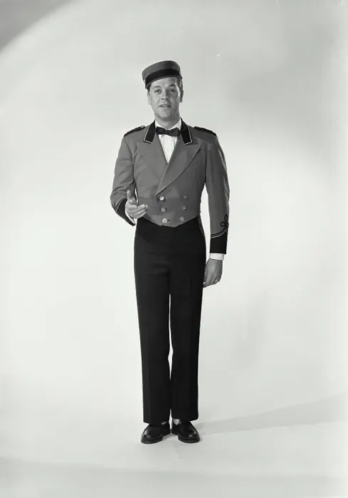 Framed Print : Vintage Photograph. Man wearing bellman uniform standing on white background Framed Print : Vintage Photograph. Man wearing bellman uniform standing on white background