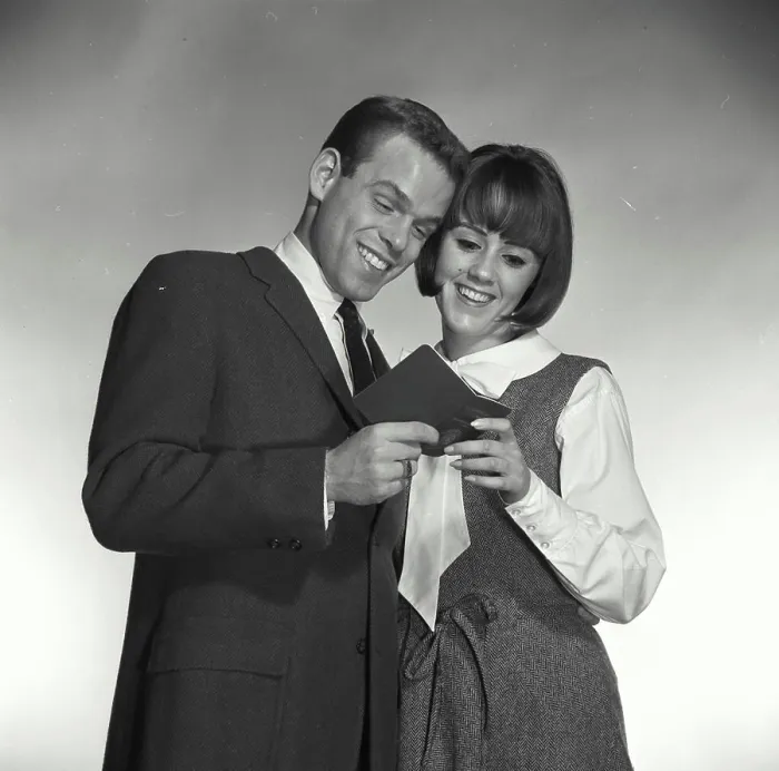 Framed Print : Vintage Photograph. A man and woman looking at bank book smiling Framed Print : Vintage Photograph. A man and woman looking at bank book smiling