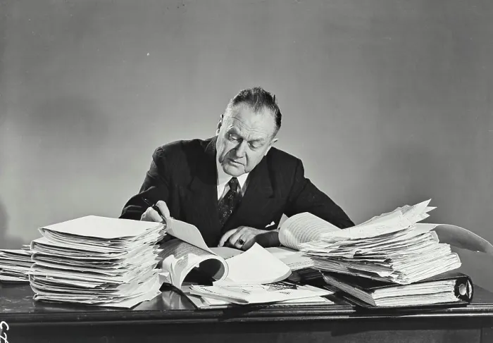 Framed Print : Vintage photograph. Older man in pinstripe suit sitting at desk full of papers Framed Print : Vintage photograph. Older man in pinstripe suit sitting at desk full of papers
