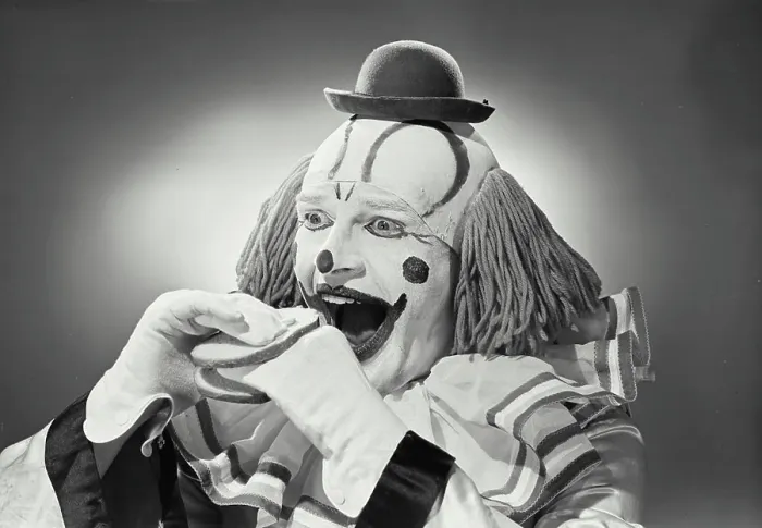 Framed Print : Vintage photograph. Portrait of clown wearing silly hat with hand sandwiched between two pieces of bread