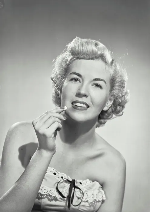 Framed Print : Vintage photograph. portrait of woman in strapless dress smiling at camera holding pill