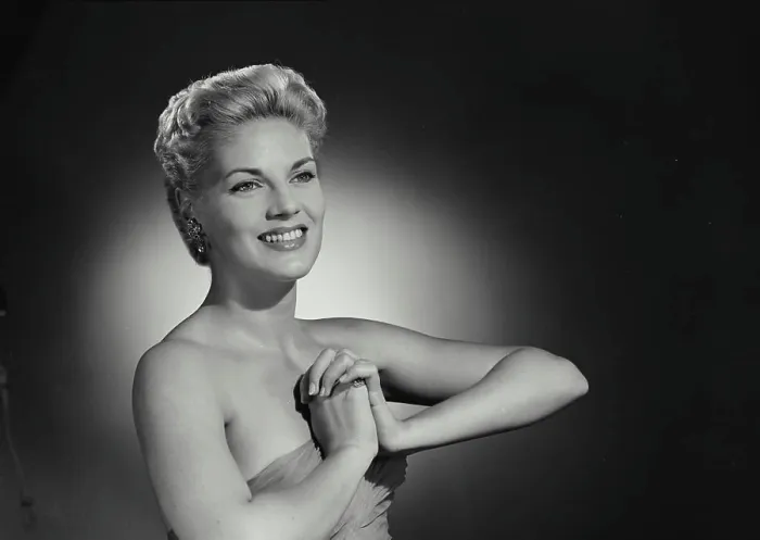 Framed Print : Vintage Photograph. Smiling blonde woman with hair up and low cut gown clasping hands together in front of chest