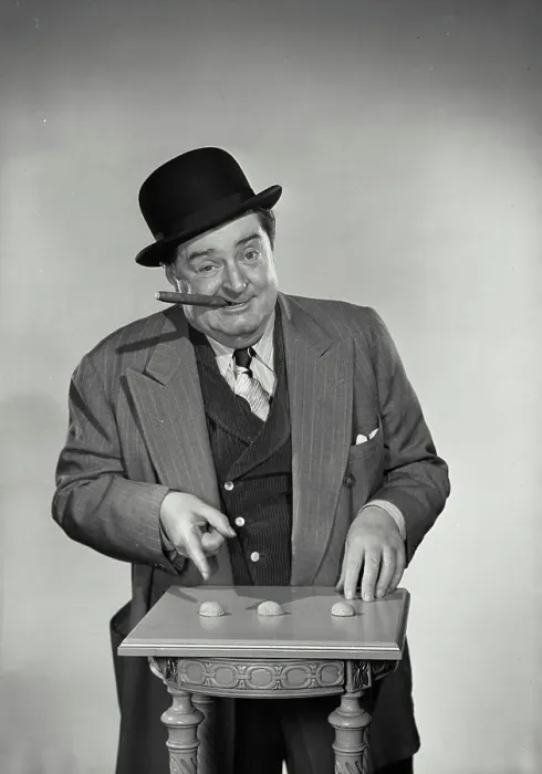Framed Print : Vintage Photograph. Street gambler with cigar in mouth pointing at shells of nuts for game Framed Print : Vintage Photograph. Street gambler with cigar in mouth pointing at shells of nuts for game