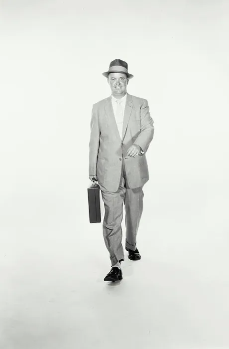 Framed Print : Vintage Photograph. A studio shot of a man wearing a suit and holding a briefcase walking towards the camera. Frame 1 Framed Print : Vintage Photograph. A studio shot of a man wearing a suit and holding a briefcase walking towards the camera. Frame 1