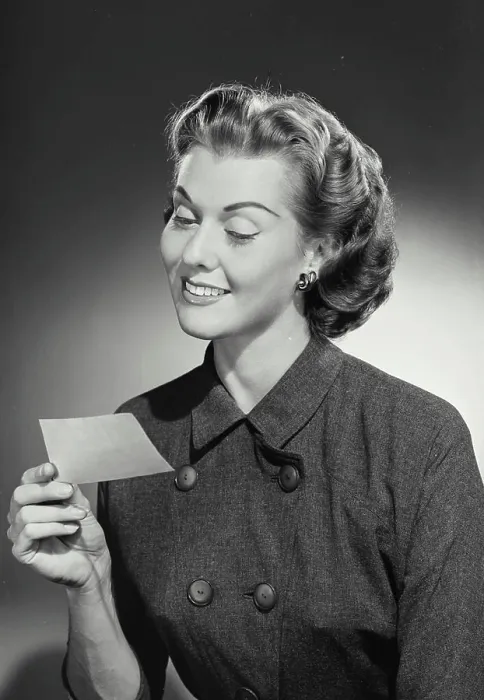 Framed Print : Vintage Photograph. Woman in coat smiling at slip of paper Framed Print : Vintage Photograph. Woman in coat smiling at slip of paper