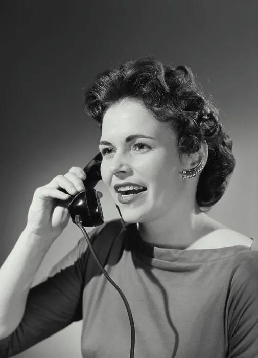 Framed Print : Vintage Photograph. Woman with curled hairstyle holding up telephone receiver having conversation Framed Print : Vintage Photograph. Woman with curled hairstyle holding up telephone receiver having conversation