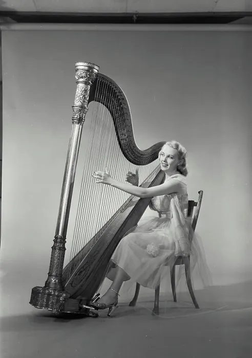 Framed Print : Vintage Photograph. Woman in dress sitting in chair playing Grand Pedal Harp. Frame 8 Framed Print : Vintage Photograph. Woman in dress sitting in chair playing Grand Pedal Harp. Frame 8