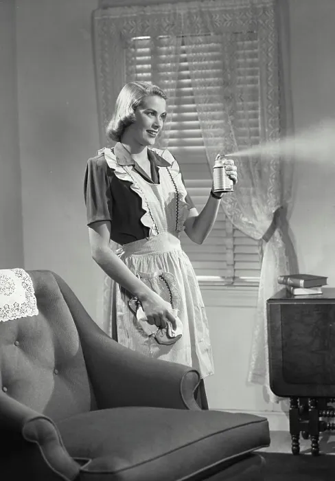 Framed Print : Vintage photograph. Woman in kitchen apron spraying air freshener Framed Print : Vintage photograph. Woman in kitchen apron spraying air freshener
