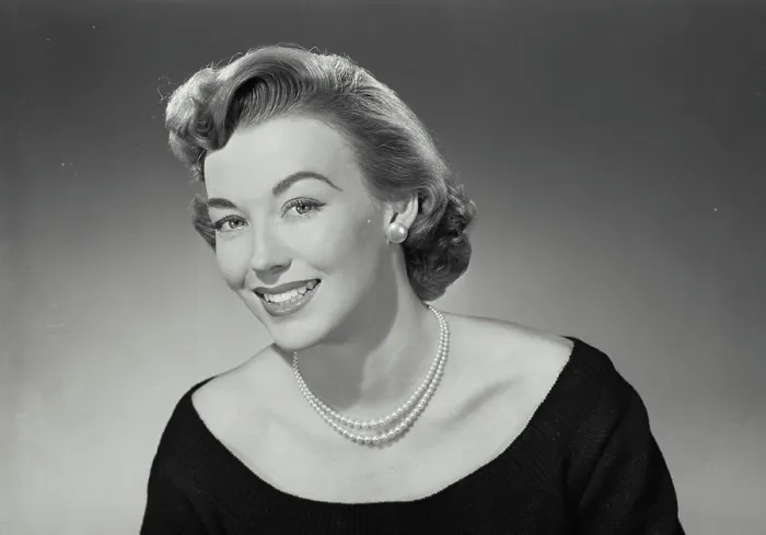 Framed Print : Vintage Photograph. Woman in low cut blouse and pearl necklace smiling wide at camera