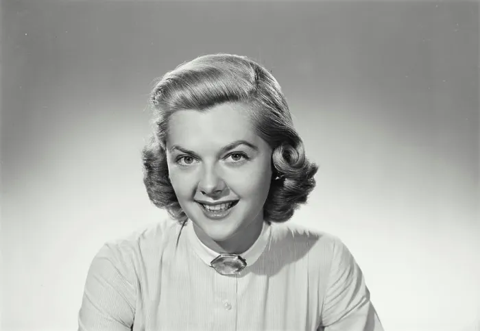 Framed Print : Vintage Photograph. Woman smiles and wears a white shirt on a white background in studio portrait Framed Print : Vintage Photograph. Woman smiles and wears a white shirt on a white background in studio portrait