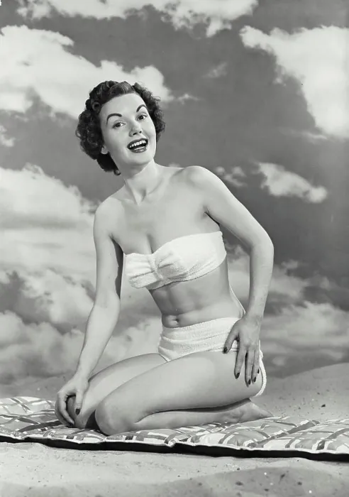 Framed Print : Vintage photograph. Woman smiling in swimsuit kneeling on mat in sand Framed Print : Vintage photograph. Woman smiling in swimsuit kneeling on mat in sand