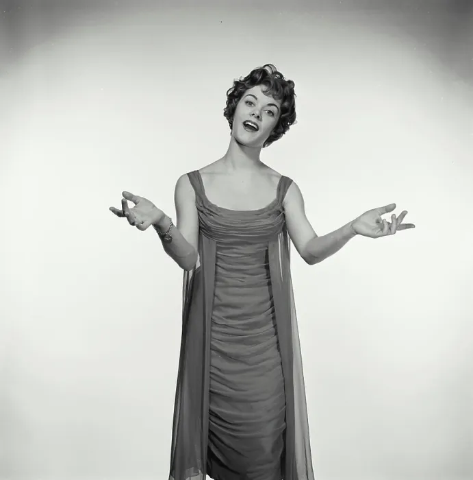 Framed Print : Vintage Photograph. Woman in studio portrait has her hands up to her sides while she sings