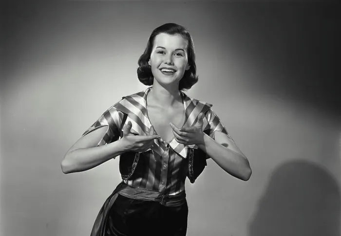 Framed Print : Vintage Photograph. Woman wears silky striped shirt while having her hands raised she smiles in studio portrait Framed Print : Vintage Photograph. Woman wears silky striped shirt while having her hands raised she smiles in studio portrait