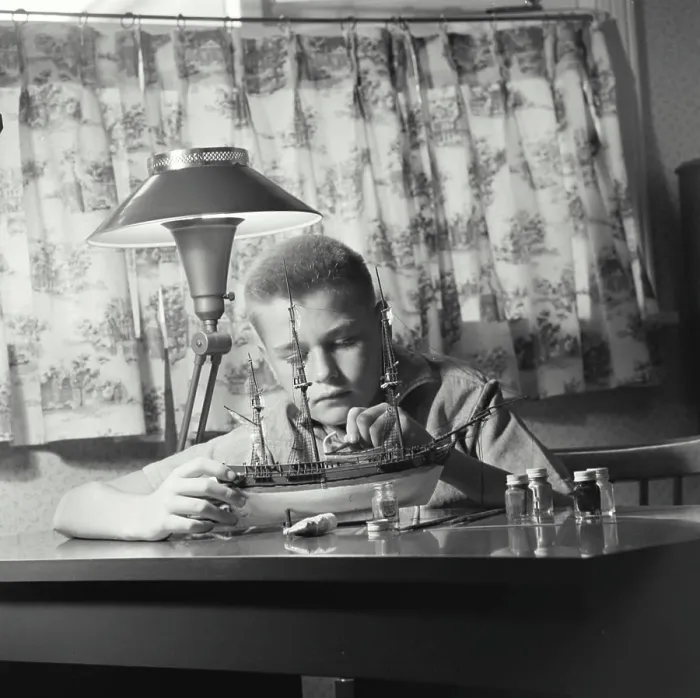 Framed Print : Vintage Photograph. young boy sitting at desk working on building model ship Framed Print : Vintage Photograph. young boy sitting at desk working on building model ship