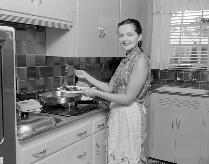 Framed Print : Woman holding plate with food in the kitchen and looking at camera Framed Print : Woman holding plate with food in the kitchen and looking at camera