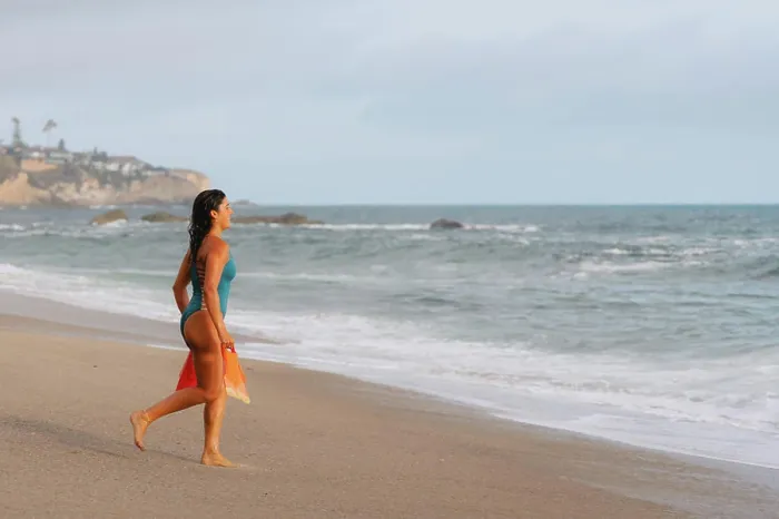 Framed Print : Woman holding swim fins running into water Framed Print : Woman holding swim fins running into water