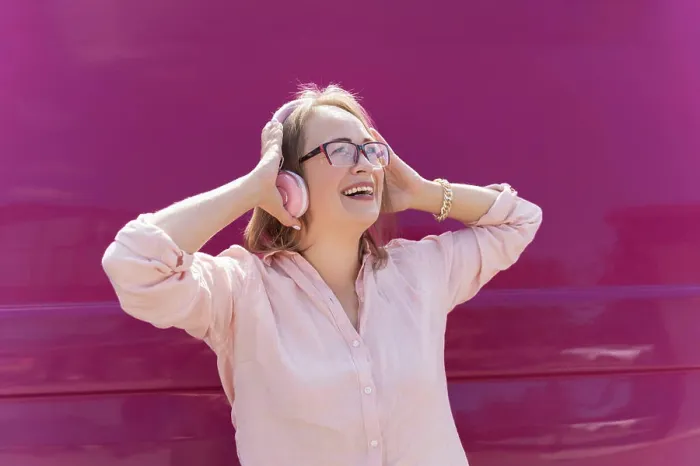 Framed Print : woman listens music in headphones and laughs on pink background Framed Print : woman listens music in headphones and laughs on pink background