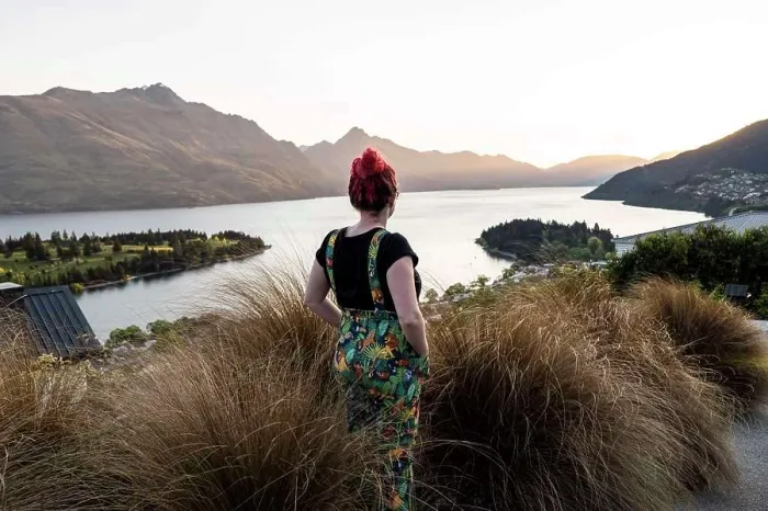 Framed Print : Woman overlooking Queenstown and lake, at sunset in New Zealand