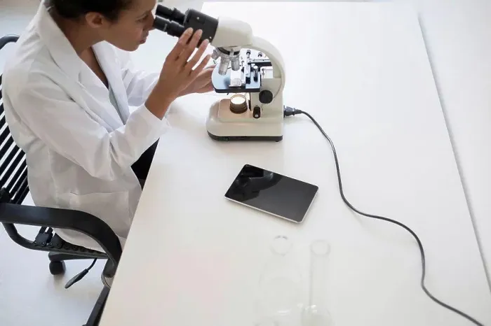 Framed Print : Woman scientist looking through microscope Framed Print : Woman scientist looking through microscope