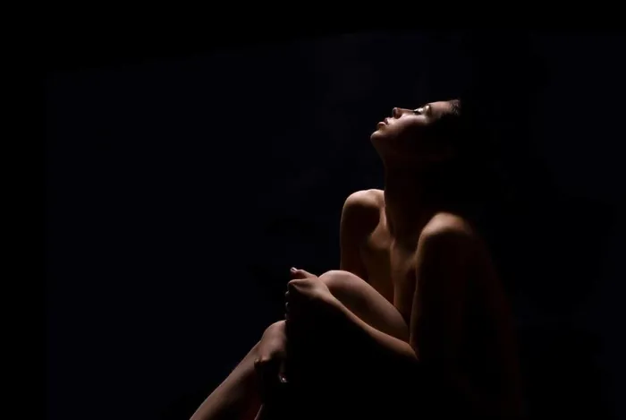 Framed Print : A woman sits with her knees drawn up to her chest, her head tilted back and her eyes closed, copy space Framed Print : A woman sits with her knees drawn up to her chest, her head tilted back and her eyes closed, copy space