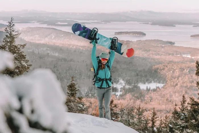 Framed Print : Woman with ski goggles and snowboard on mountain overlooking lake