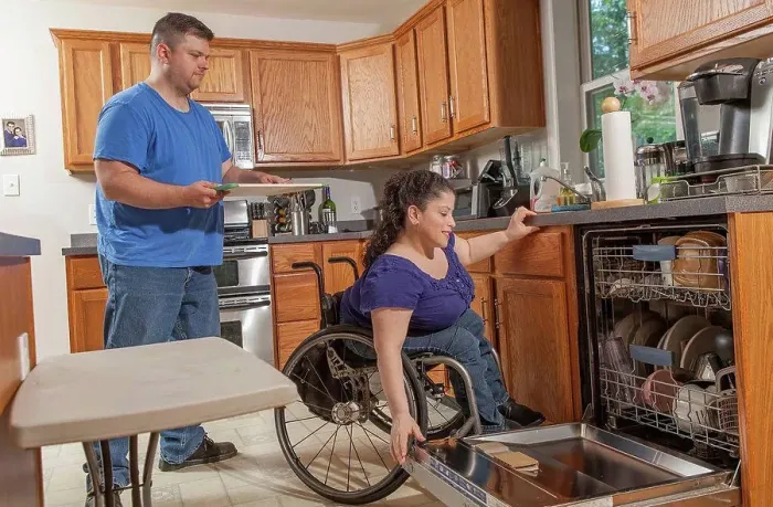 Framed Print : Woman with Spina Bifida and her husband using the dishwasher in kitchen Framed Print : Woman with Spina Bifida and her husband using the dishwasher in kitchen
