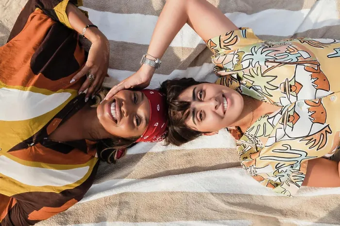 Framed Print : Woman touching lesbian friend lying on picnic blanket at beach Framed Print : Woman touching lesbian friend lying on picnic blanket at beach