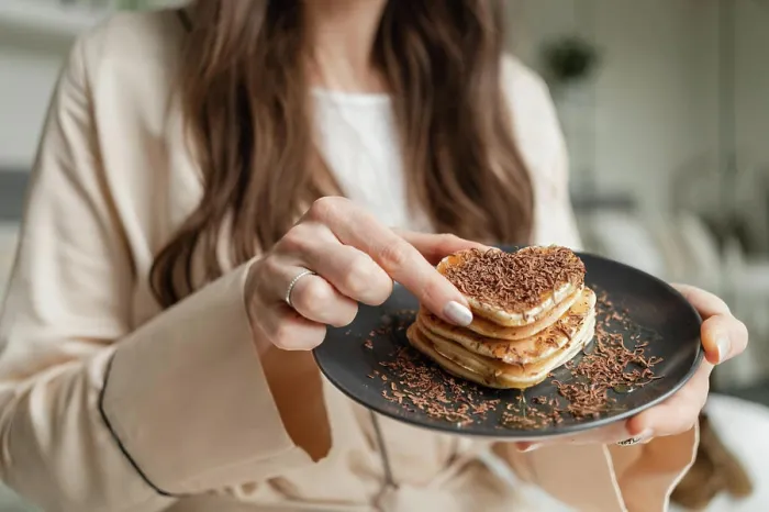 Framed Print : Woman trying heart shaped pancakes with grated chocolate for breakfast Framed Print : Woman trying heart shaped pancakes with grated chocolate for breakfast