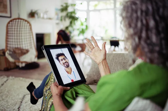 Framed Print : Woman video chatting with doctor on digital tablet screen