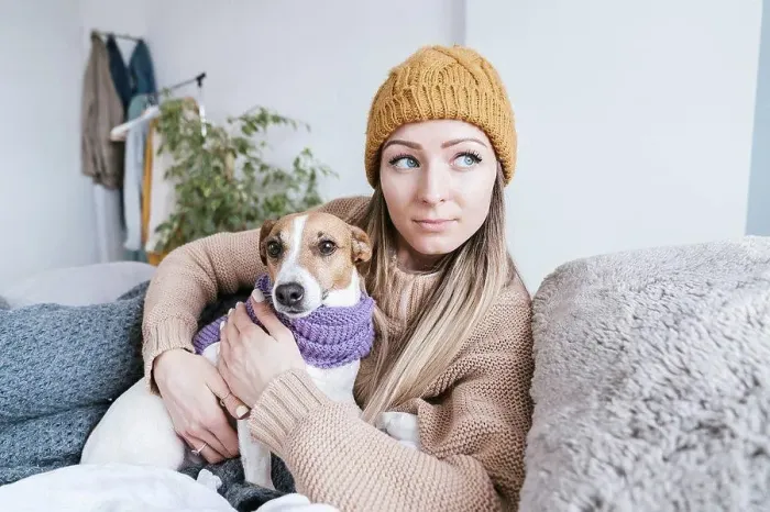 Framed Print : Woman wearing warm clothing cuddling with dog in bed Framed Print : Woman wearing warm clothing cuddling with dog in bed