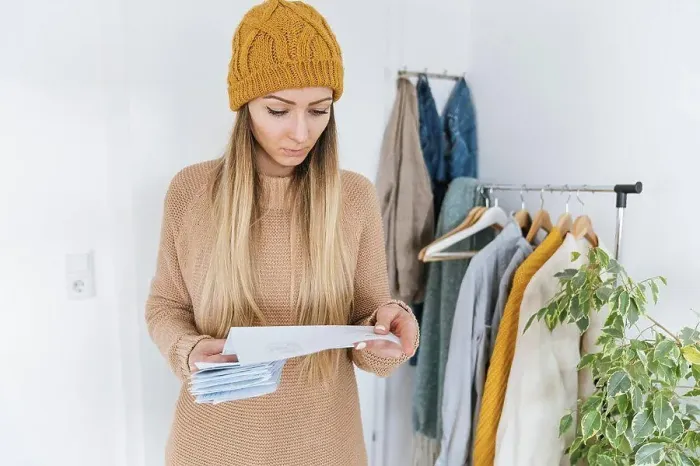 Framed Print : Woman with wooly checking bills standing in dressing room Framed Print : Woman with wooly checking bills standing in dressing room