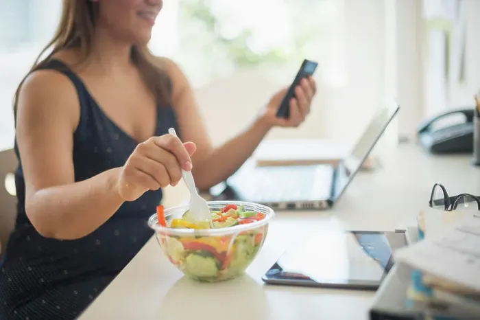Framed Print : Woman working in home office and eating salad Framed Print : Woman working in home office and eating salad