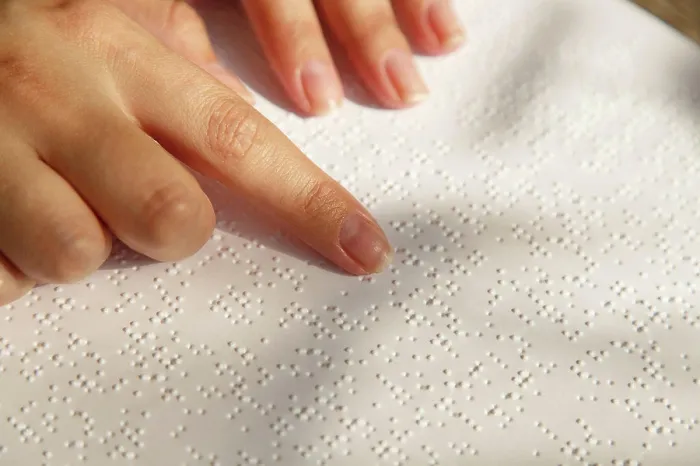Framed Print : Woman's hand on a book page with braille. Female finger Framed Print : Woman's hand on a book page with braille. Female finger