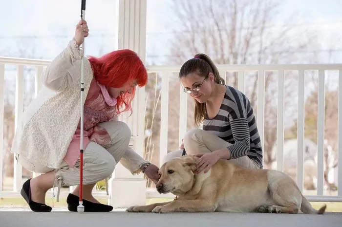 Framed Print : Two women with visual impairments, one with a service dog and one with a cane