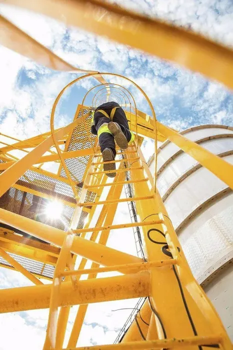 Framed Print : Worker climbing up ladder at tank Framed Print : Worker climbing up ladder at tank