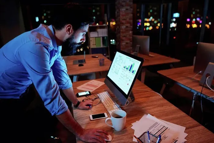Framed Print : Young businessman working at computer on office desk at night Framed Print : Young businessman working at computer on office desk at night